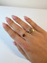 A golden butterfly ring is woorn on the ring finger of a women.. The butterfly is in gold and the band is in silver.