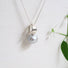 A 925 silver pendant inspired by natural forms like leaves has a large grey freshwater pearl hanging from the base of it.