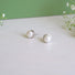 Genuine round 6 mm luminous white pearls are nestled into an organic round silver rimmed setting with a post.