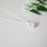 A luminous round genuine white pearl, elegantly suspended within a 10 mm hand crafted sterling silver setting.