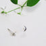 Tiny Pair of crescent shaped stud earring featuring a small 2 mm white round pearl in the centre of the crescent.