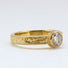 A gold solitaire diamond ring. Hand engraved with scrolls, leaves and flowers in Victorian style.