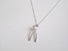 A wishbone shaped sterling silver pendant accented with a small 3 mm white freshwater pearl at the heart of the wishbone .