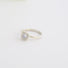 A diamond solitaire ring with prong and bezel set stone on a fine slighlty wavy textured band.