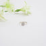 A diamond solitaire ring with prong and bezel set stone on a fine textured band.