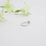 Back view of a diamond solitaire ring with prong and bezel set stone on a fine textured band.
