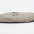 A silver band composed of organic forms which are engraved with ribbons of lines that represent flowing water