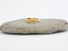 A 14 karat yelw gold band composed of segments of organic forms which are engraved with ribbons of lines that represent flowing water