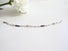 A silver bracelet made with paper clip links and Blue Sapphire, Genuine Pearl, and Deep Red Garnet beads.