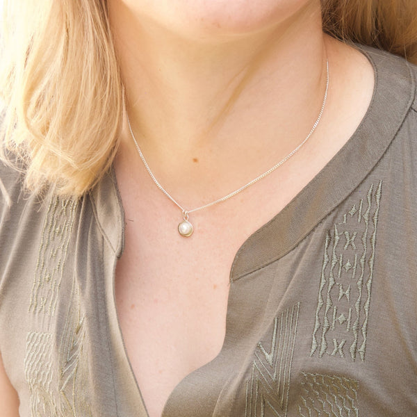 Model shows a 6 mm round pearl set in a handcrafted silver pendant 