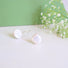 A pair of white genuine freshwater round  10 mm wide coin pearls with a silver ear hook. 