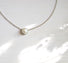 An 8 mm round white freshwater pearl  set into a sterling silver bezel that floats on a 16" sterling silver cable chain
