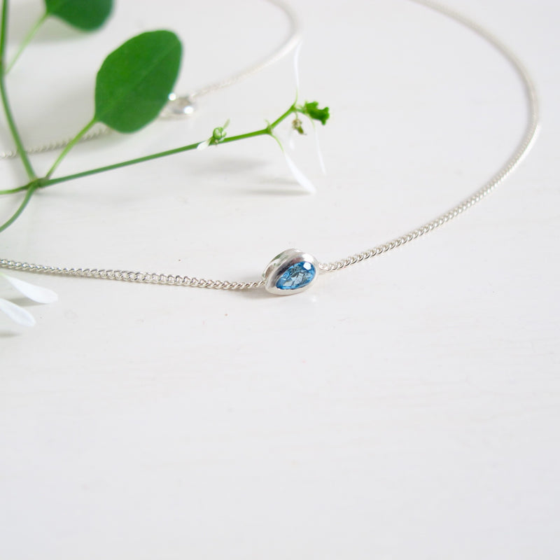 A 3 x 5 mm London faceted Pear shaped London Blue Topaz stone set in sterling silver is floating from a fine 16" sterling silver chain