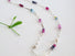  Authentic gemstones: Blue topaz, Garnets, Rhodolite garnets. Rubies  Sapphires and genuine pearls are arranged in an artful and asymmetrical design on a sterling silver paper clip link chain