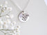 Large coin shaped silver medallion 2 cm in diameter with cut out leaf shapes and a small pearl accent. 