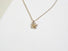 A delicate 10 mm flower constructed with 5 silver daisy like petals and 3  14 karat yellow gold balls that sit in the centre of the flower that  suggest the stamens of the flower. Each petal is hand formed and stamped to resemble a petal's form. The flower is easily recognizable and hangs from a 16 " silver curb chain.