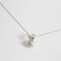 A 925 silver pendant inspired by natural forms like leaves has a large grey freshwater pearl hanging from the base of it.