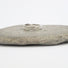 A silver band composed of organic  forms which are engraved with ribbons of lines that represent flowing water
