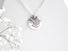 Large coin shaped silver medallion 2 cm in diameter with cut out leaf shapes and a small pearl accent. 