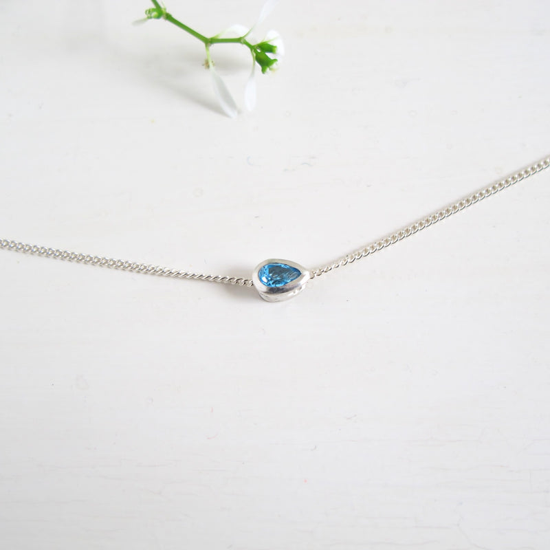 A 3 x 5 mm London faceted Pear shaped London Blue Topaz stone set in sterling silver is floating from a fine 16" sterling silver chain