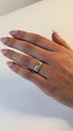 A woman's hand wears a diamond solitaire ring and is moving to catch the flashes light in her cushion cut diamond.