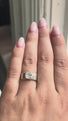 woman with an oval diamond ring moves her hand to show off the diamond.