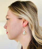 A large teardrop shaped freshwater pink pearl dangles from a handcrafted silver crescent stud earring