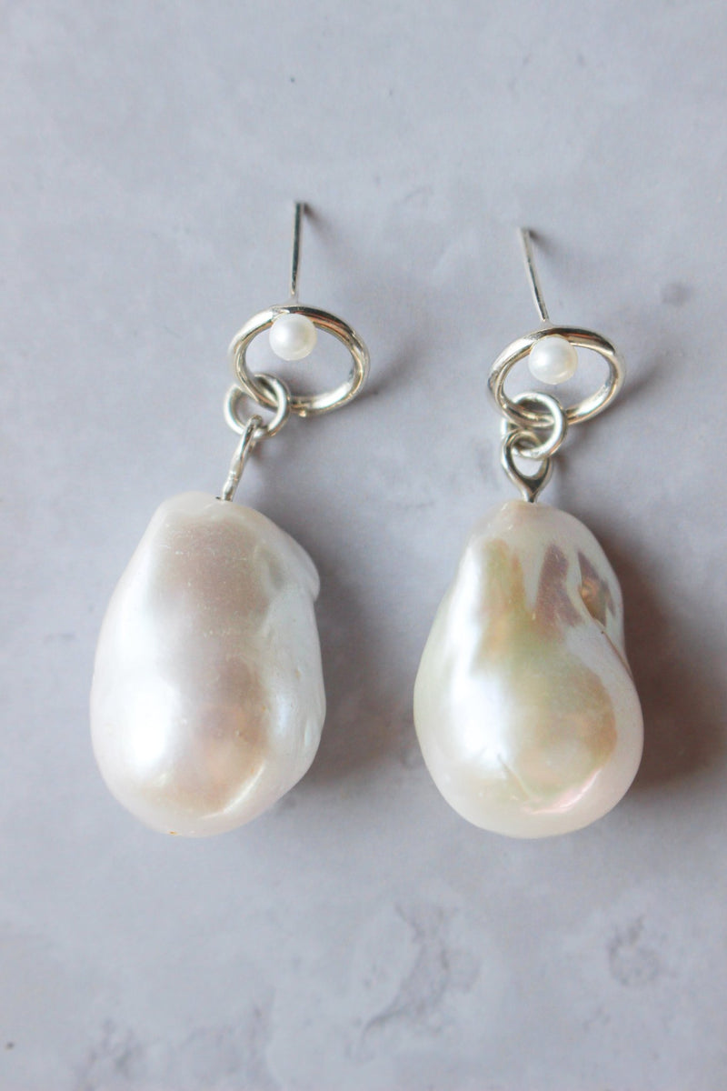  large Baroque pearls dangles below a soft-edged silver halo stud with a tiny pearl adorning the top.p.