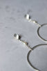 Small silver discs with ear posts drops a short chain with a pearl which connects a handcrafted large silver hoops.