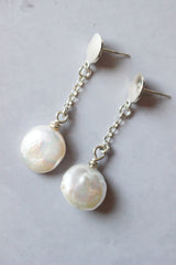 Freshwater round white coin pearl earrings hang from a Reiki imbued silver chain that attaches to a small disc stud earring