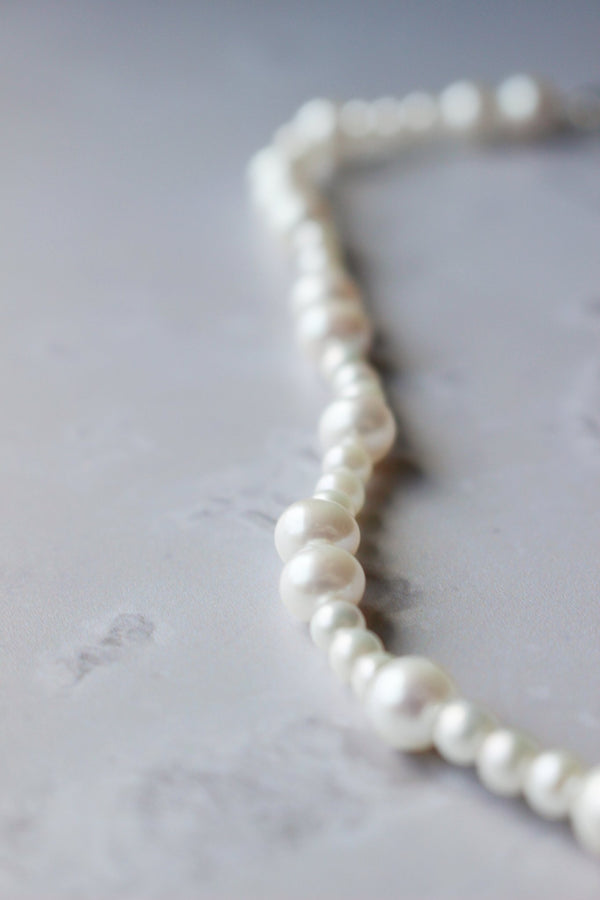 Hand knotted genuine freshwater pearl necklace strung with of various sizes of round white pearls. 