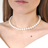 Closeup of model shows the elegant neck-hugging strand of Reiki imbued consciously sourced white freshwater round pearls.
